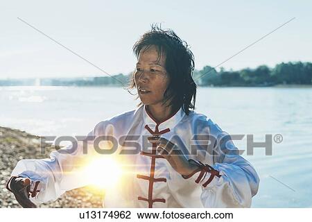 Women practicing tai chi by lake View Large Photo Image Stock Image - Women practicing tai chi by lake. Fotosearch