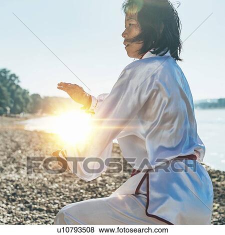 Stock Photo - Women practicing tai chi by lake. Fotosearch