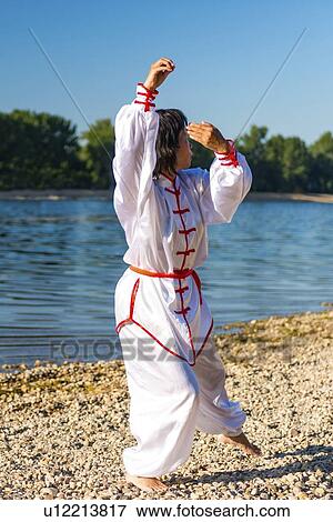 Stock Photo - Women practicing tai chi by lake. Fotosearch