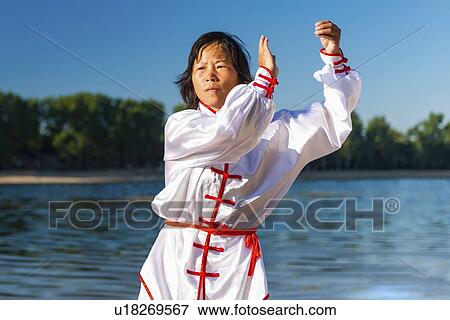 Stock Photo - Women practicing tai chi by lake. Fotosearch
