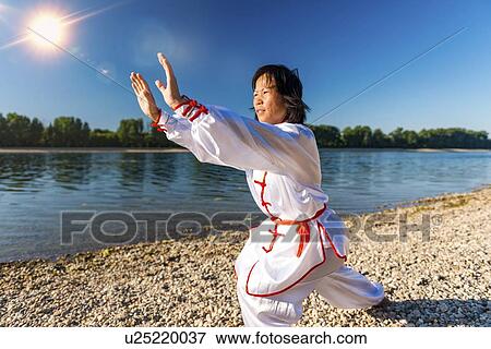Stock Photo - Women practicing tai chi by lake. Fotosearch