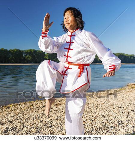 Stock Photo - Women practicing tai chi by lake. Fotosearch