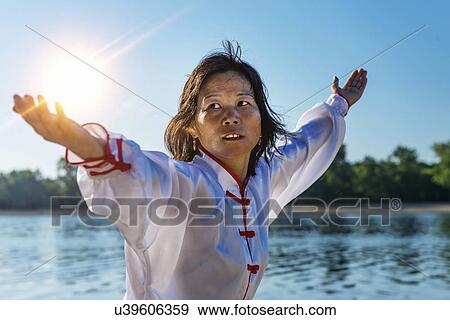 Stock Photo - Women practicing tai chi by lake. Fotosearch