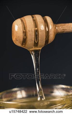 Wooden dipper with flowing honey View Large Photo Image Stock Image - Wooden dipper with flowing honey. Fotosearch