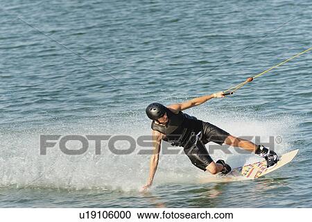 Stock Image - Young man wakeboarding. Fotosearch