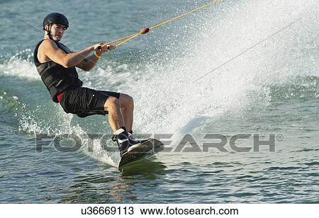 Stock Image - Young man wakeboarding. Fotosearch