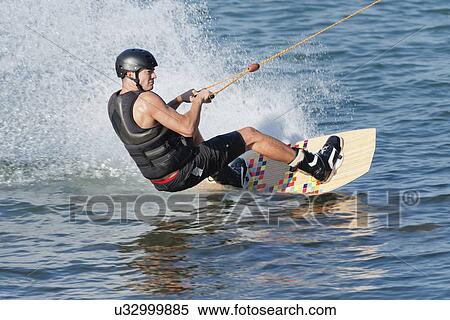 Stock Photography - Young man wakeboarding. Fotosearch