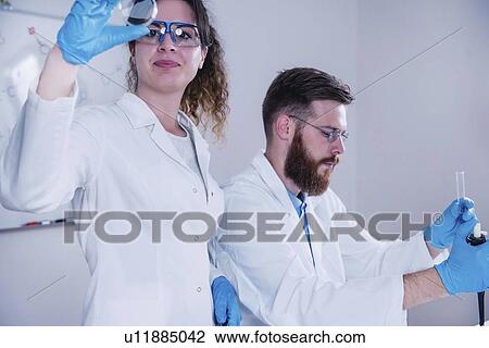 Stock Image - Young scientists working in laboratory. Fotosearch