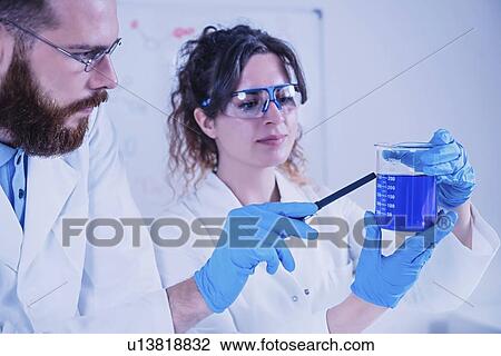 Stock Image - Young scientists working in laboratory. Fotosearch