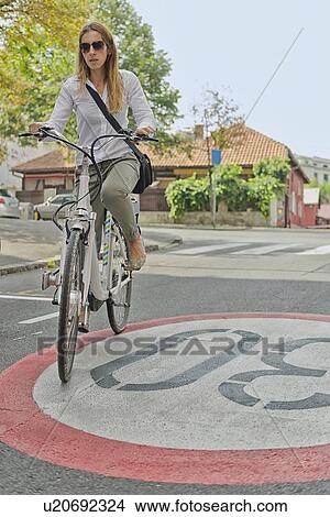 Picture - Young woman on electric bicycle. Fotosearch