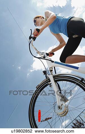 Young woman riding electric bicycle View Large Photo Image Stock Image - Young woman riding electric bicycle. Fotosearch