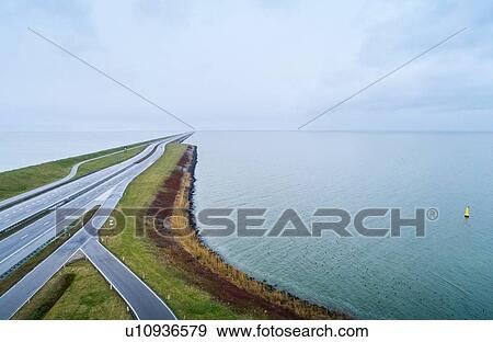 Afsluitdijk, a large dike connects Friesland with north of Holland in 1933. Transforming Zuidersea into an enormous fresh water lake named IJsselmeer, Kornwerderzand, Friesland, Netherlands View Large Photo Image Stock Photo - Afsluitdijk, a large dike connects Friesland with north of Holland in 1933. Transforming Zuidersea into an enormous fresh water lake named IJsselmeer, Kornwerderzand, Friesland, Netherlands. Fotosearch