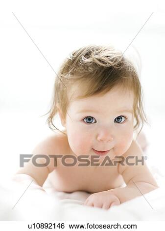 Stock Photograph - Baby girl lying on her front. Fotosearch