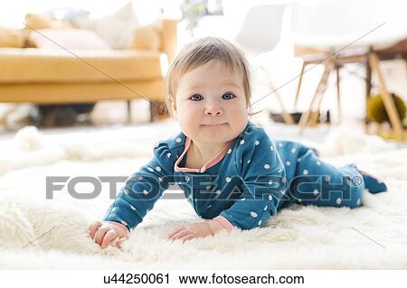 Baby girl lying on rug View Large Photo Image Stock Image - Baby girl lying on rug. Fotosearch