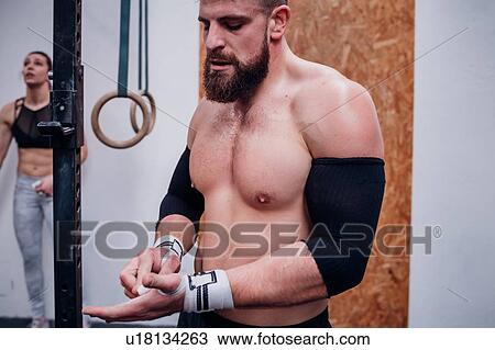 Bare chested young man training, chalking hands in gym View Large Photo Image Stock Image - Bare chested young man training, chalking hands in gym. Fotosearch