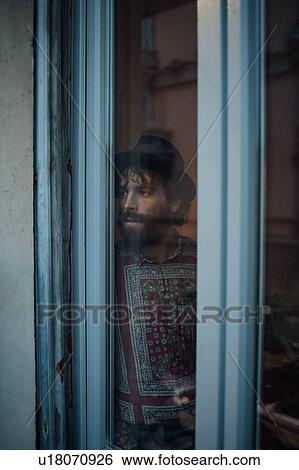 Bearded young man in deep thought by window View Large Photo Image Stock Photograph - Bearded young man in deep thought by window. Fotosearch