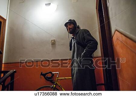 Bearded young man leaving home with bicycle View Large Photo Image Stock Photo - Bearded young man leaving home with bicycle. Fotosearch