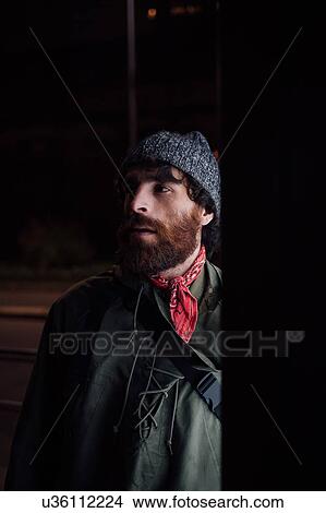 Picture - Bearded young man loitering on street. Fotosearch