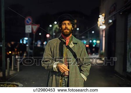 Stock Image - Bearded young man loitering on street. Fotosearch