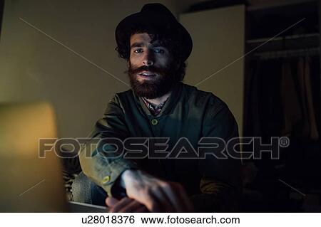 Bearded young man using laptop at home View Large Photo Image Stock Photograph - Bearded young man using laptop at home. Fotosearch
