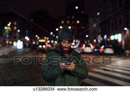 Bearded young man using smartphone on street View Large Photo Image Picture - Bearded young man using smartphone on street. Fotosearch