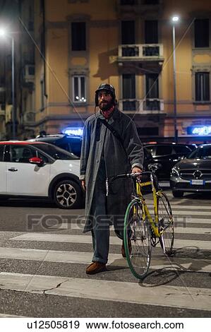 Bearded young man walking on pedestrian crossing with bicycle View Large Photo Image Stock Photo - Bearded young man walking on pedestrian crossing with bicycle. Fotosearch