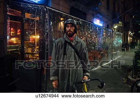 Picture - Bearded young man with bicycle on pavement. Fotosearch