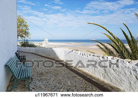Stock Image - Benches on footpath by beach in Cacela, Portugal. Fotosearch