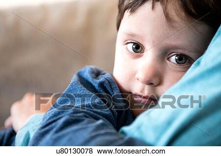 Stock Photo - Big brother hugging toddler on sofa. Fotosearch