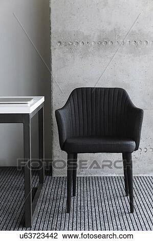 Stock Image - Black chair by desk. Fotosearch