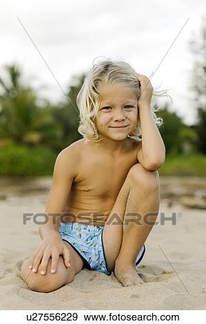 Blond haired boy kneeling on beach View Large Photo Image Stock Photo - Blond haired boy kneeling on beach. Fotosearch