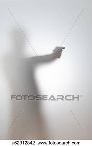 Stock Image - Blurred silhouette of a man with a gun.. Fotosearch