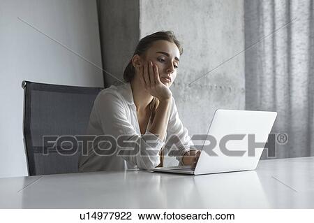 Bored businesswoman working on laptop View Large Photo Image Stock Image - Bored businesswoman working on laptop. Fotosearch