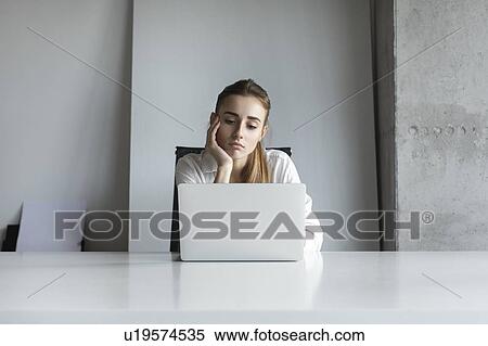 Bored businesswoman working on laptop View Large Photo Image Stock Photography - Bored businesswoman working on laptop. Fotosearch