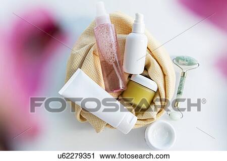 Stock Image - Bottles of skin care with a face massager. Fotosearch