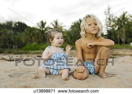 Boy and his baby sister sitting on beach View Large Photo Image Stock Image - Boy and his baby sister sitting on beach. Fotosearch