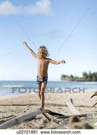 Boy balancing on driftwood View Large Photo Image Stock Image - Boy balancing on driftwood. Fotosearch