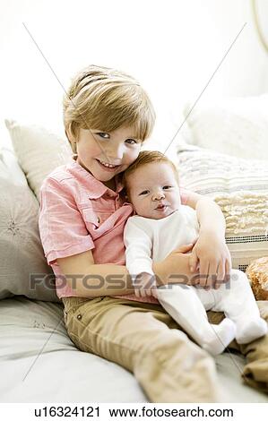 Stock Image - Boy holding his baby brother. Fotosearch