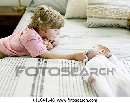 Boy holding his baby brothers pacifier View Large Photo Image Stock Photo - Boy holding his baby brothers pacifier. Fotosearch
