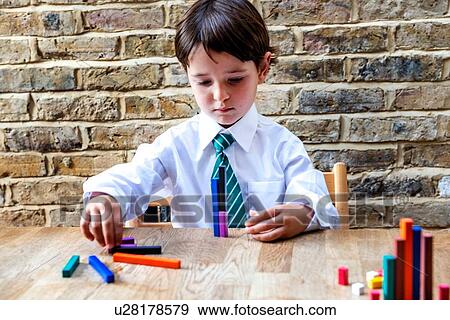 Boy in school uniform playing with colour sticks at home View Large Photo Image Stock Photo - Boy in school uniform playing with colour sticks at home. Fotosearch