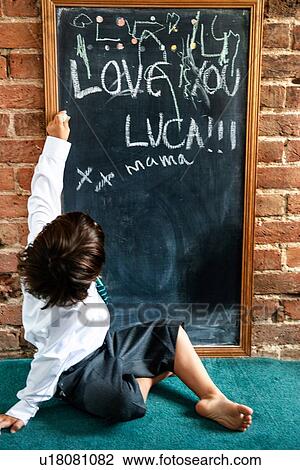 Boy in school uniform writing on blackboard at home View Large Photo Image Stock Image - Boy in school uniform writing on blackboard at home. Fotosearch