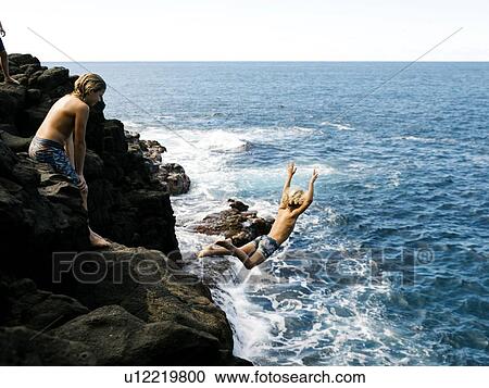 Boy jumping off cliff by sea View Large Photo Image Stock Image - Boy jumping off cliff by sea. Fotosearch