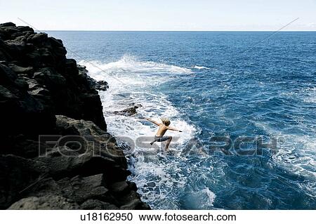 Boy jumping off cliff by sea View Large Photo Image Stock Image - Boy jumping off cliff by sea. Fotosearch