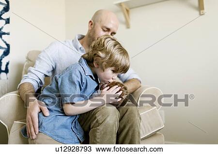Boy kissing his baby brother on his father's lap View Large Photo Image Stock Image - Boy kissing his baby brother on his father's lap. Fotosearch
