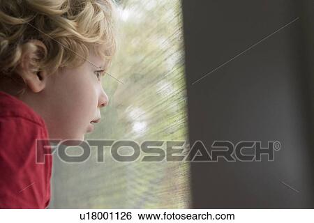 Stock Photograph - Boy looking out window. Fotosearch
