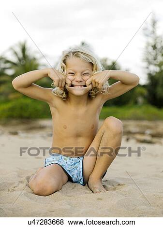 Boy making face on beach View Large Photo Image Stock Photo - Boy making face on beach. Fotosearch