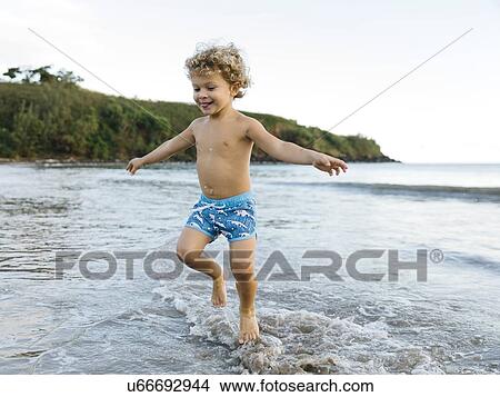 Picture - Boy playing on beach. Fotosearch