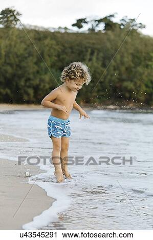 Stock Image - Boy playing on beach. Fotosearch