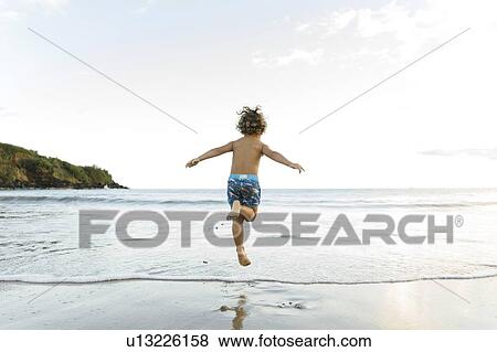 Stock Photo - Boy playing on beach. Fotosearch