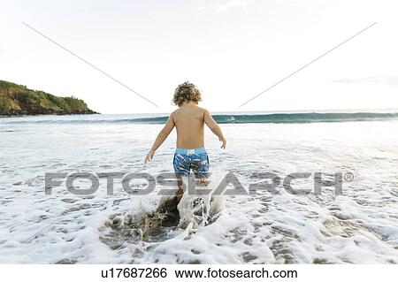 Stock Photograph - Boy playing on beach. Fotosearch